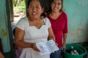 Dos mujeres mexicanas mostrando su libreta de ahorro.
